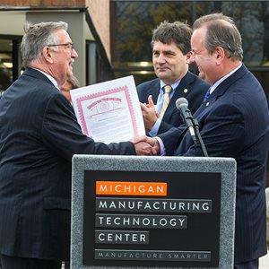 Michael Coast (left) receives a tribute from State Senator Patrick Colbeck, State Representative Kurt Heise (right).